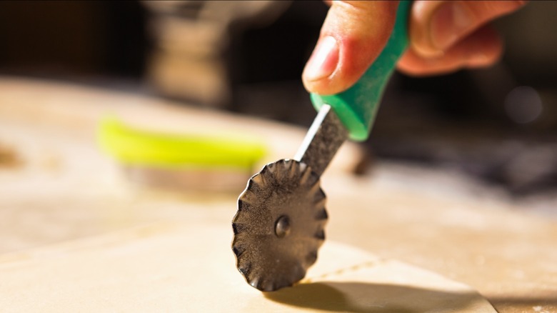 Small pastry wheel cutting dough