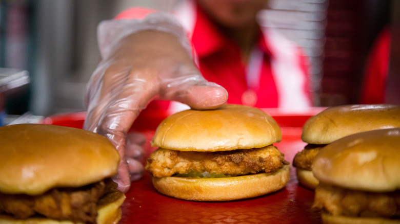 An employee grabs a chicken sandwich