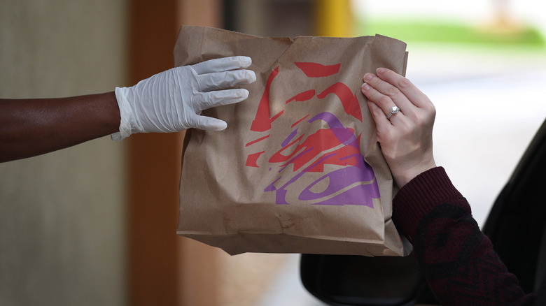 Employee handing off Taco Bell purchase 