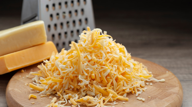 grated cheddar on wooden board