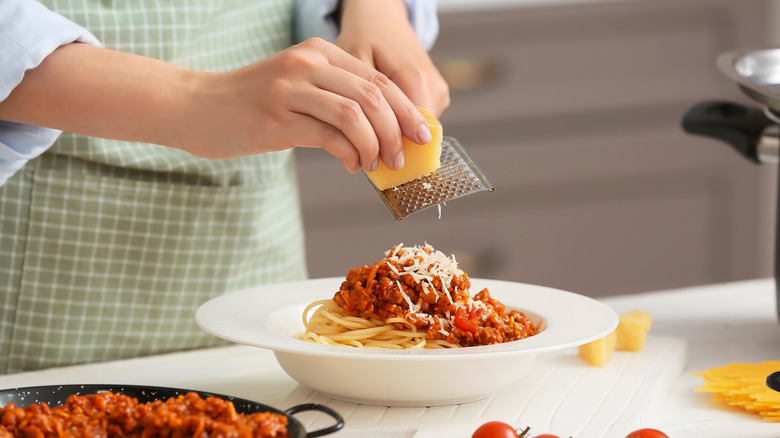 Grating cheese on pasta