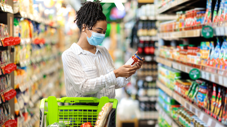 grocery store customer looking at jar