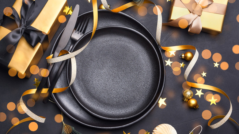 Empty black plate surrounded by New Year's Eve party decorations