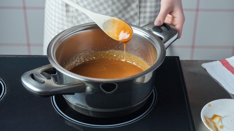 person making caramel sauce in saucepan on the stovetop