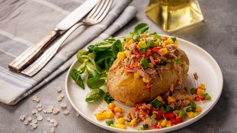 baked potato with tuna corn on white plate