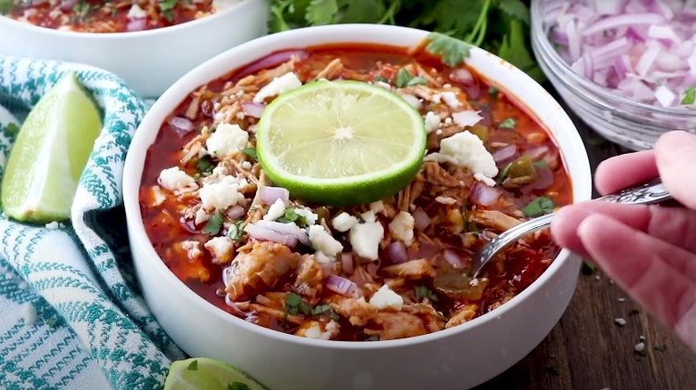 white bowl of pulled pork chili with lime slice