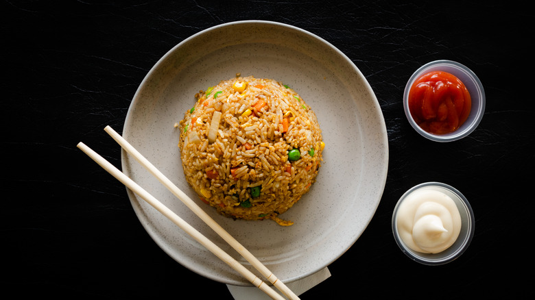 fried rice dome on plate with ketchup and mayo