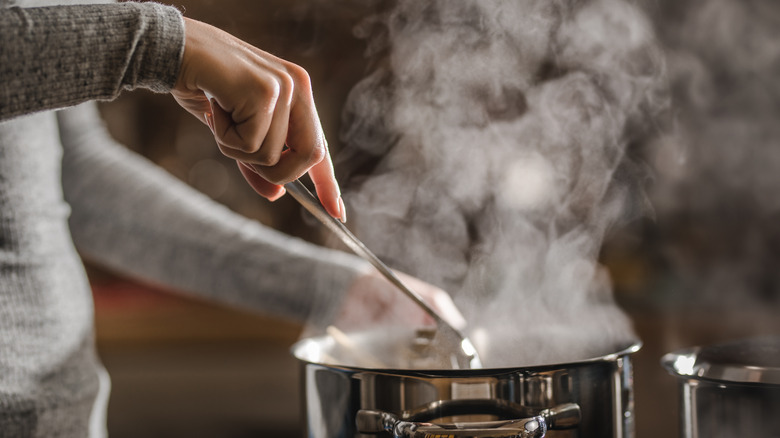 Person cooking food in pot