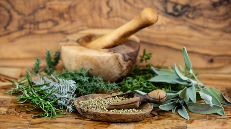 fresh herbs and a wood bowl of dried herbs that comprise a traditional herbs de Provence