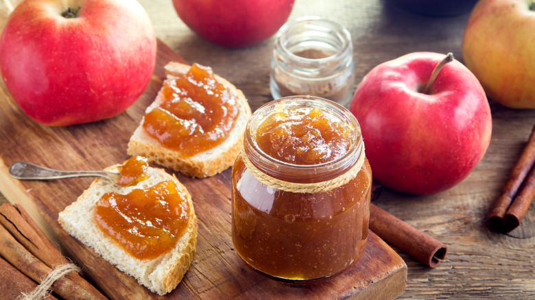 homemade apple butter in jar on wooden board