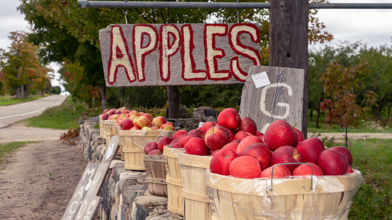 apples for sale in baskets on stone wall