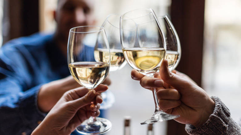 People toasting with glasses of white wine