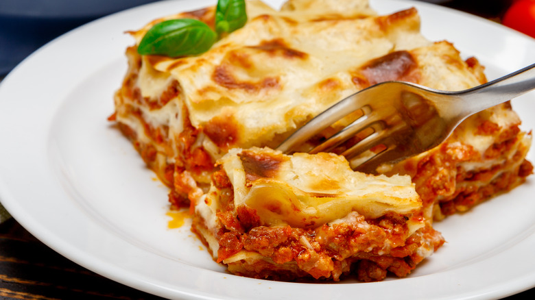 cutting into lasagna with fork