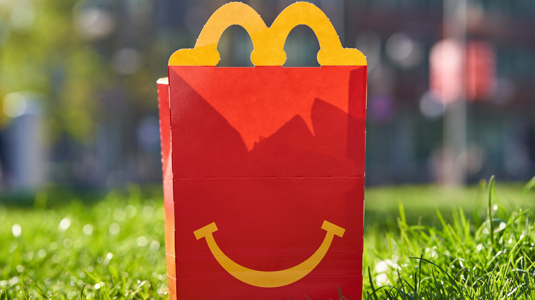 McDonald's happy meal box sitting in field of grass