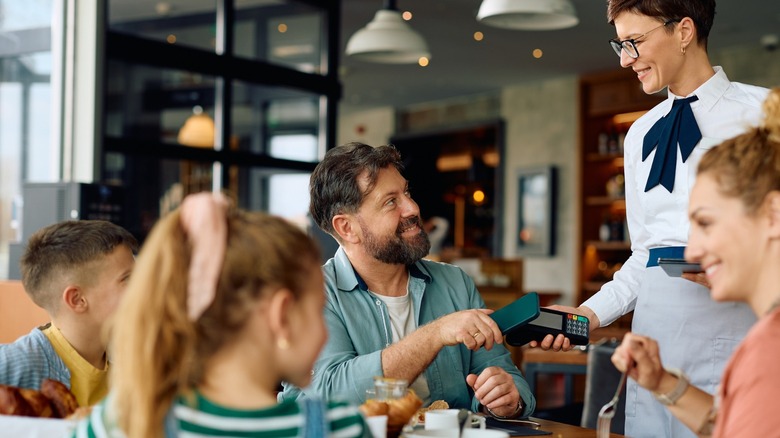 man pays check at restaurant