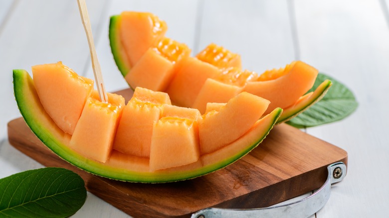 Sliced cantaloupe on wooden board