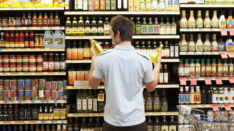 shopper comparing bottles of olive oil