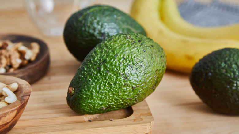 Whole avocados on cutting board