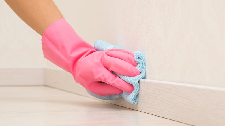 Person cleaning baseboards