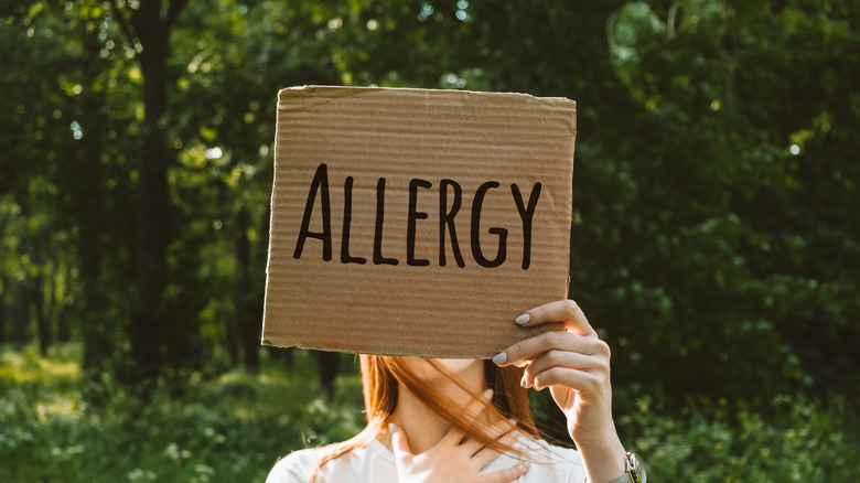 Woman holding up allergy sign