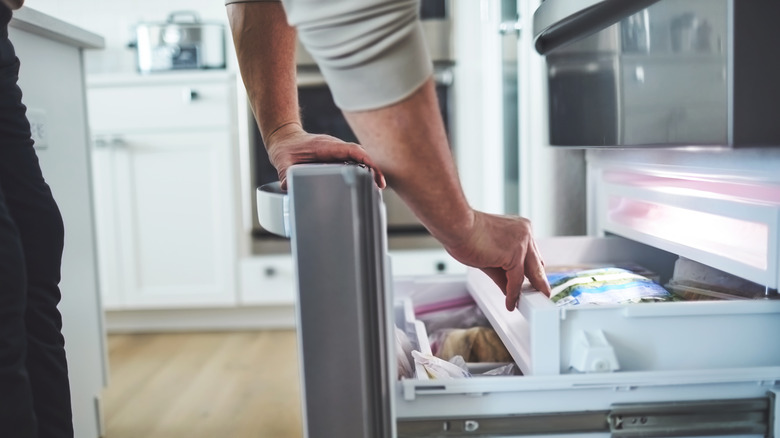 person opening freezer drawer