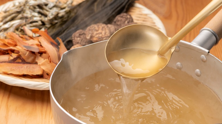 homemade broth in ladle over soup pan