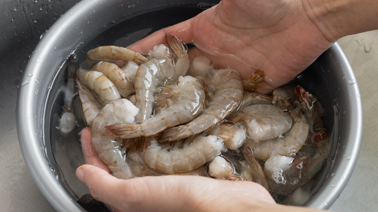 person washing shrimp 