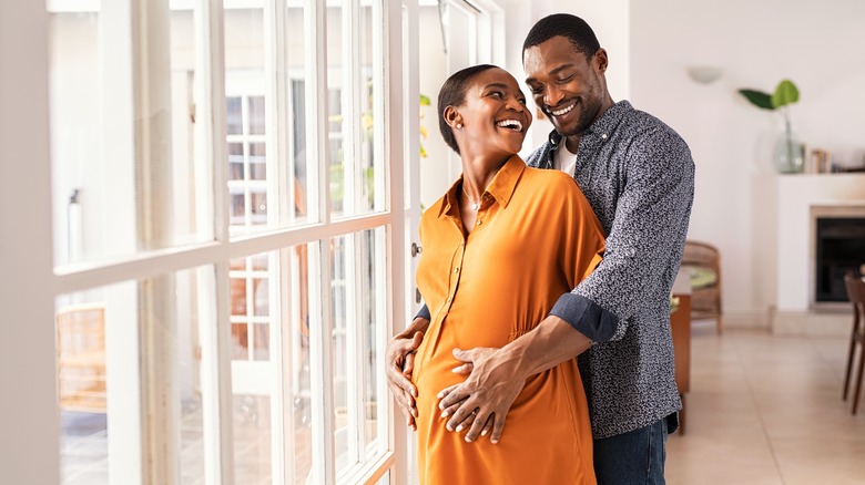 couple with hands on pregnant belly