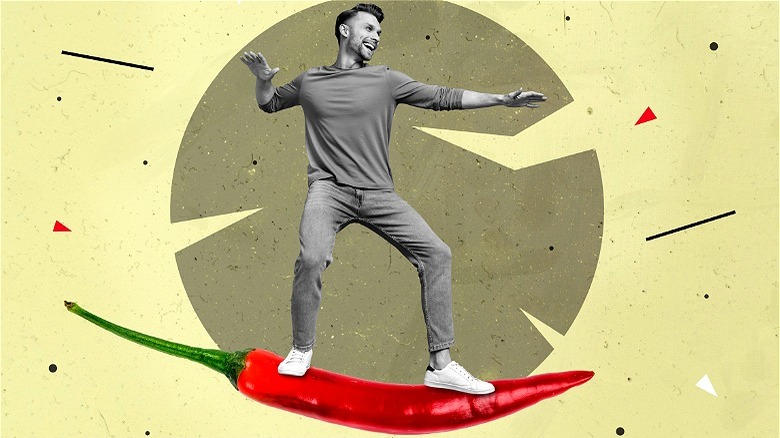 Happy man surfing on chili pepper 