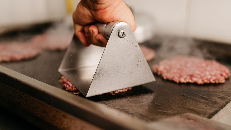 flattening a patty for smash burgers