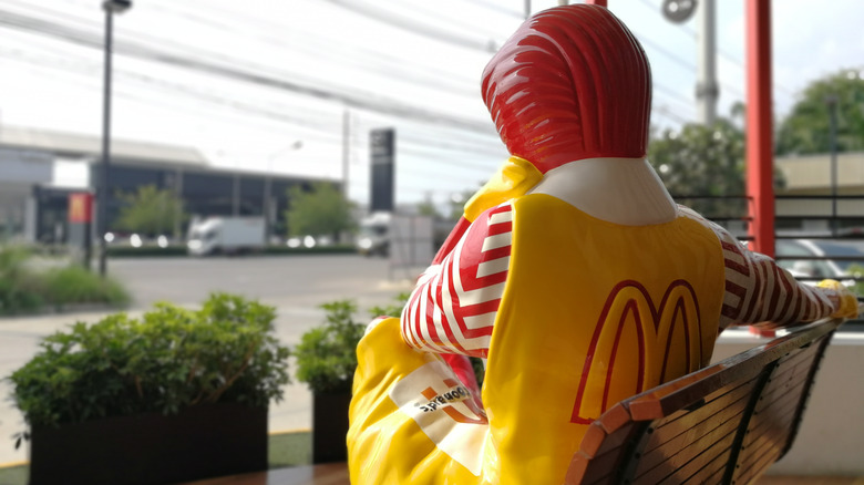 Ronald McDonald statue sitting on a bench