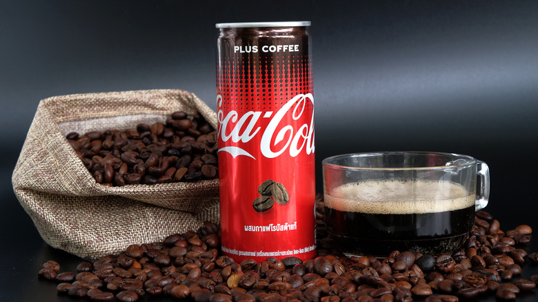 can of Coca Cola Plus Coffee surrounded by coffee beans 