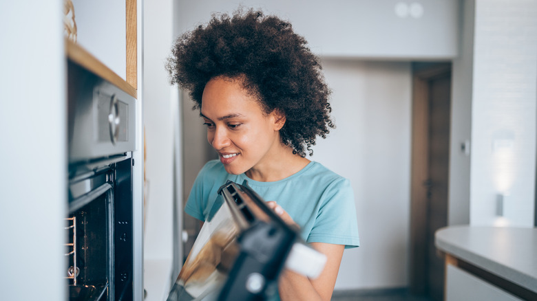 Woman peeking into oven