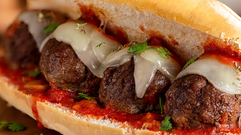 Close-up of a meatball sub with marinara sauce and melted cheese