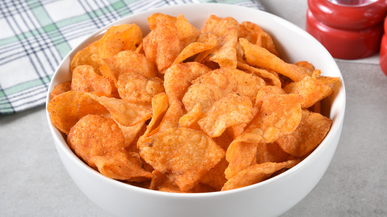 Bowl of seasoned potato chips on tablecloth