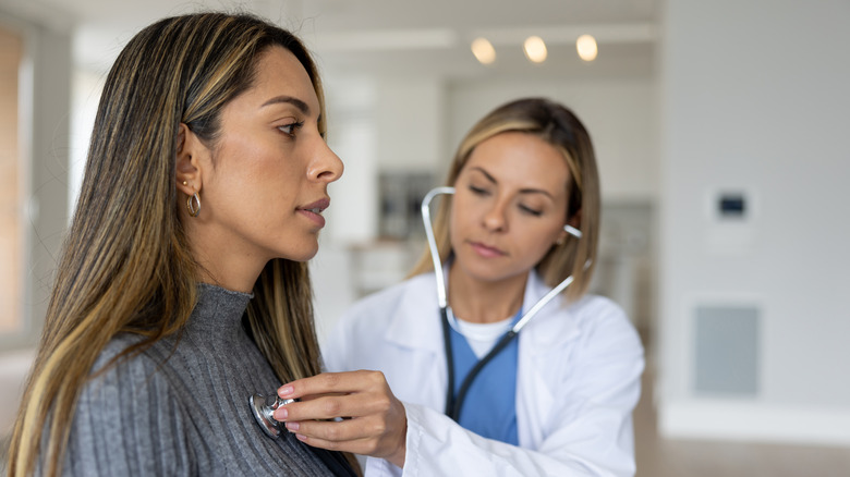 Doctor listens to patient heartbeat