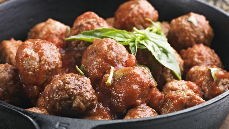 meatballs in a pan with basil