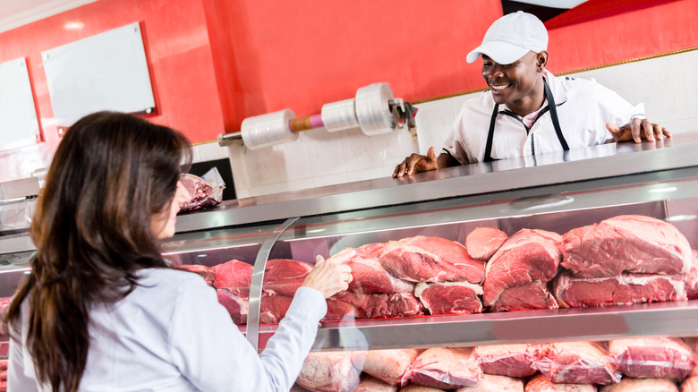 customer pointing out meat to butcher