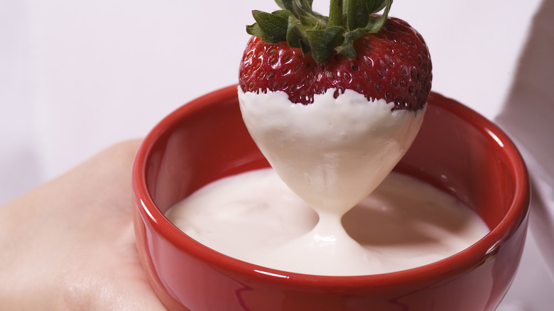 dipping strawberry in melted chocolate