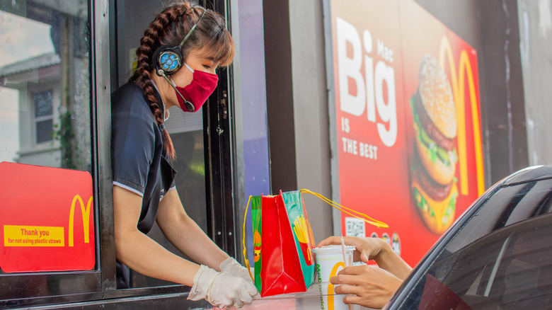 McDonald's employee handing order to customer at drive thru