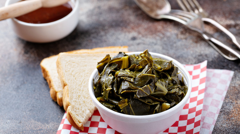 Bowl of collards next to white bread