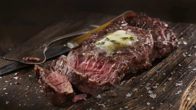 cooked moose meat steak on chopping board