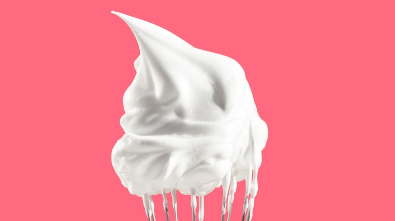 Soft peak whipped cream on whisk