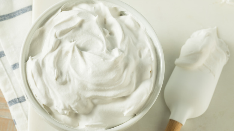 Spatula next to a bowl of whipped cream