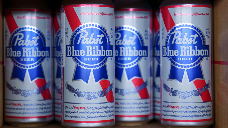 Tall boy cans of Pabst Blue Ribbon in a cardboard box