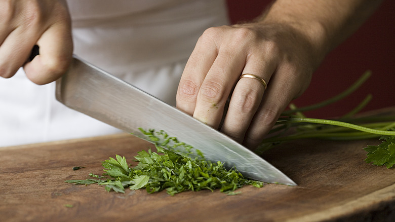 Chopping parsley on cutting board