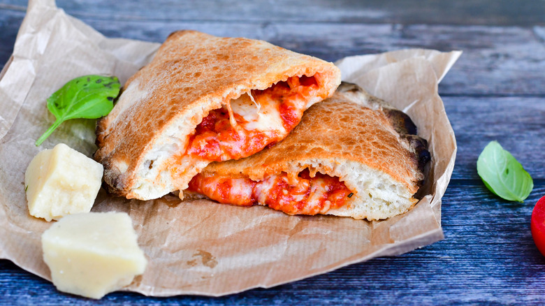 Halved calzone on brown paper