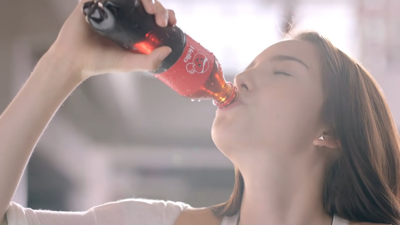 Woman drinking Coca-Cola bottle