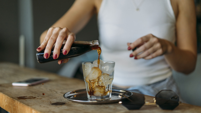 woman pouring cold brew over ice