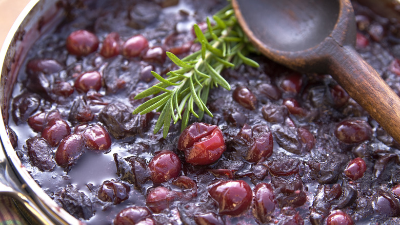 Homemade cranberry sauce with rosemary sprig and wooden spoon